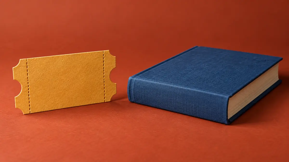 Event admission and a book Admission ticket beside a blue clothbound book